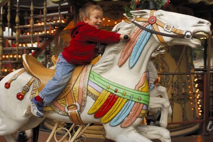 France, Paris (75), Parc de la Villette, enfant sur un cheval de bois dans un manège ancien