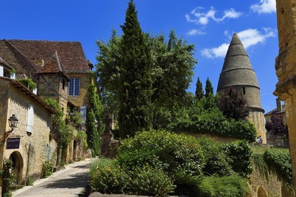 France, Dordogne, Perigord Noir, Dordogne valley, Sarlat la Caneda, old pigeon house in the Rue Montaigne left and the Lantern of the Dead (12th century) of almost 10 m high