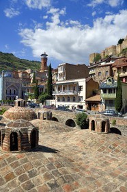 Géorgie, Tbilissi, vieille ville, quartier thermal de Abanotoubani avec les toits des bains sulfureux publiques, les Bains Orbeliani à la façade carrelée bleue, le minaret de la mosquée et la forteresse de Narikala (IVème siècle) en arrière plan