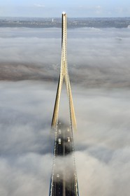 France, entre Calvados (14) et Seine-Maritime (76), le Pont de Normandie qui émerge des brumes matinales de l'automne et enjambe la Seine, vue depuis le sommet du pylone sud