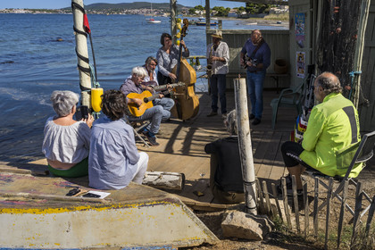 France, Hérault (34), Sète,  Pointe du Barrou sur les rives de l'étang de Thau, le groupe de musique Au Bois de mon cœur qui réinterprète les chansons de Georges Brassens, il est mené par le pêcheur sétois Jean-Louis Lambert au chant et à la guitare, Georges Cabaret à la guitare solo, Guy Blanc dit Guet au saxo alto, Denis Benito à la mandoline bluegrass et Tatiana à la contrebasse