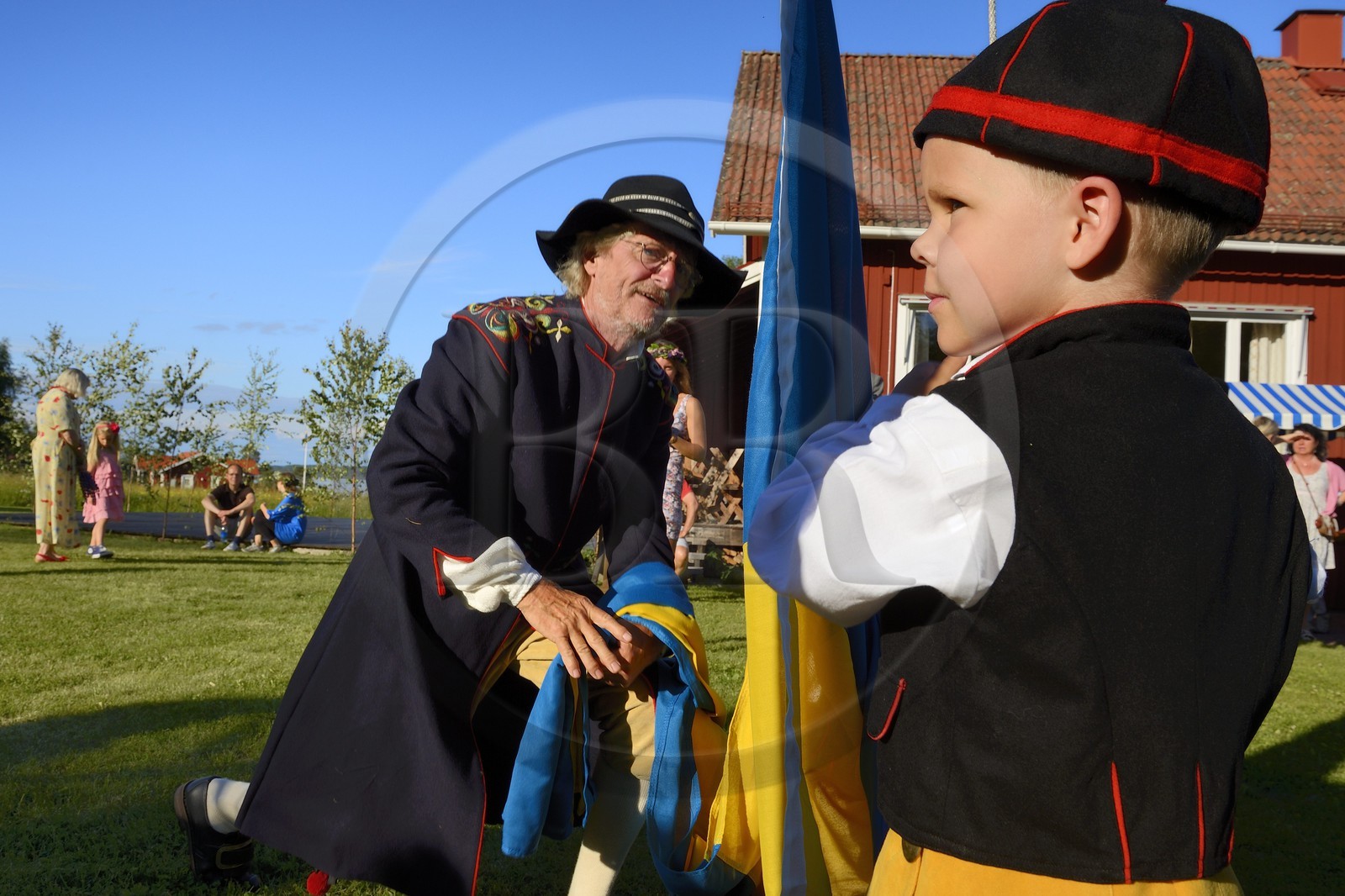 Sweden, Dalarna County, Leksand area, Midsummer celebrations in the tiny hamlet of Hjulbäck, raising the Swedish flag