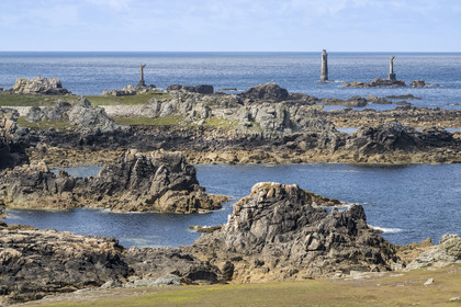 France, Finistère (29), Mer d'Iroise, Ile d'Ouessant, rochers façonnés par les tempêtes au pied du phare du Créac’h, le phare de Nividic sur la Pointe de Pern en arrière plan