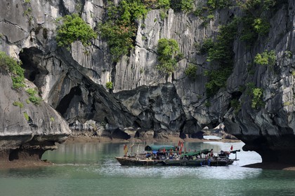 Vietnam, Quang Ninh Province, Halong Bay, listed as World Heritage by UNESCO, fishing boats under a naturel  limestone arch