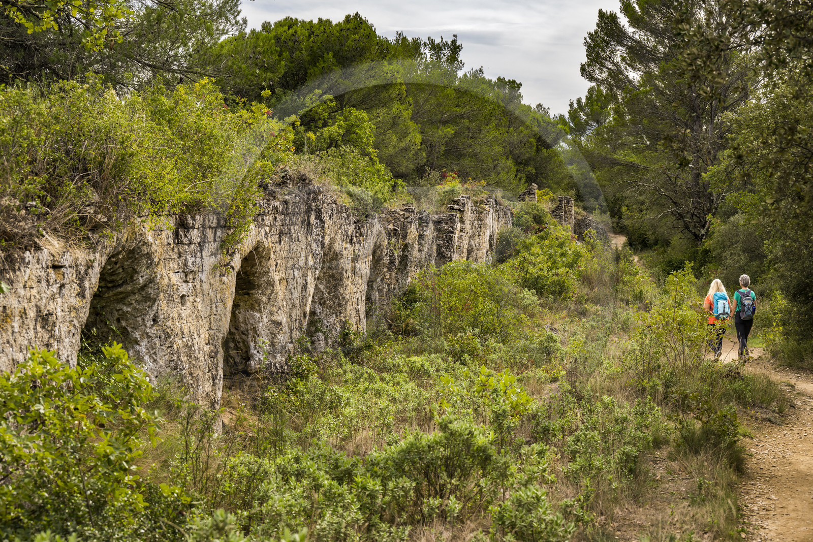 France, Gard (30), Vers-Pont-du-Gard, randonneurs longeant les vestiges de l'aqueduc romain de plus de 52 km de longueur qui amenait l'eau de la Fontaine d'Eure au pied d'Uzès jusqu'à Nimes en passant sur le Pont du Gard