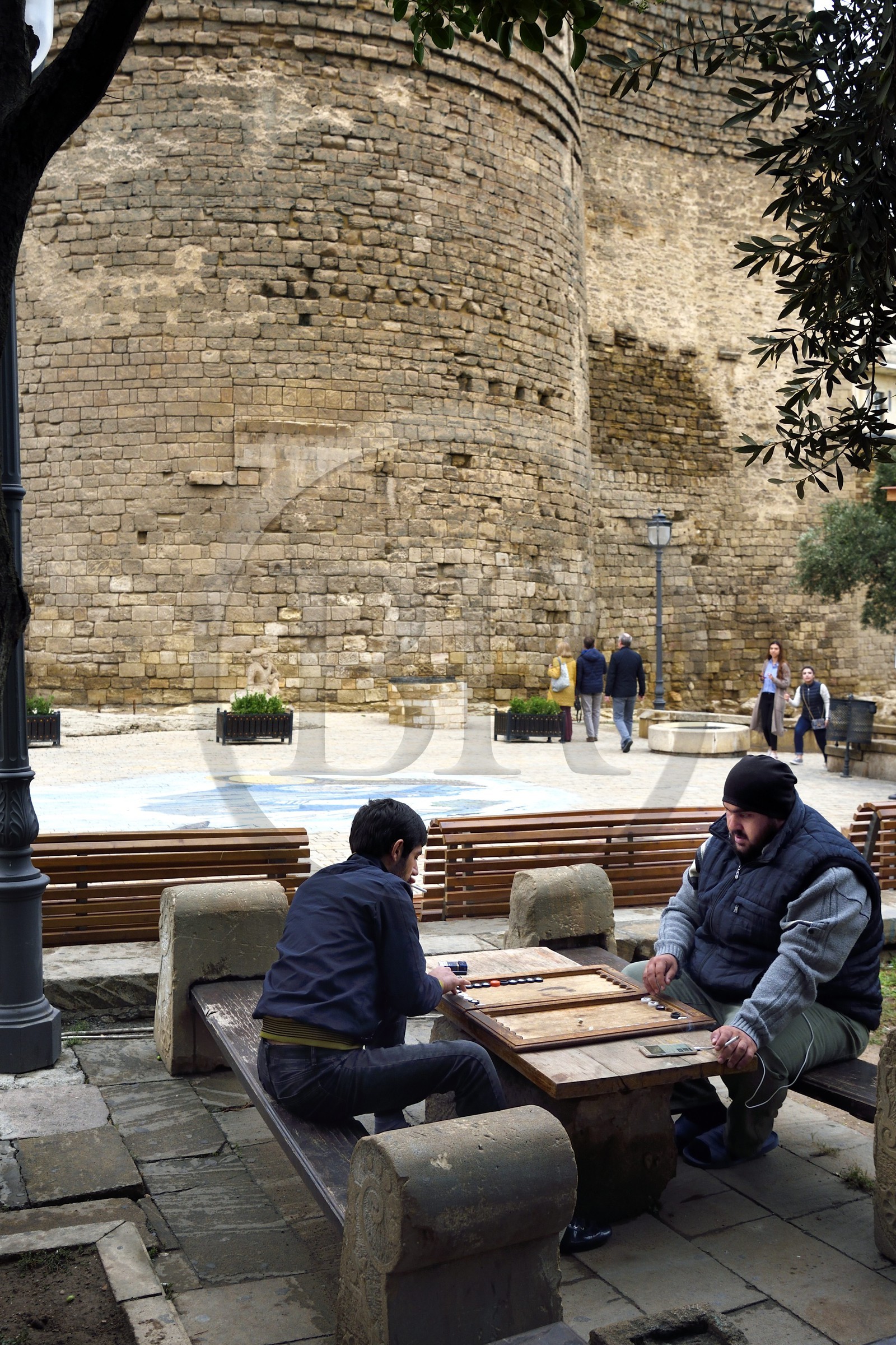 Azerbaijan, Baku, Old City, listed as World heritage by UNESCO, baggamon players at the foot of the Maiden Tower