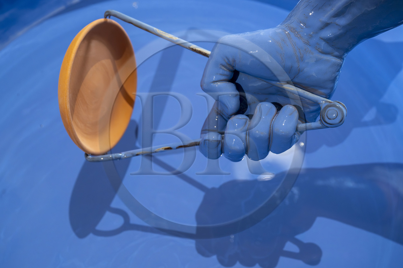 France, Nièvre (58), Nevers, Fayencerie d’art de Nevers, le maître faïencier Clair Bernard trempe le biscuit à l'aide d'une griffe métallique dans le bain d'émail Bleu de Nevers