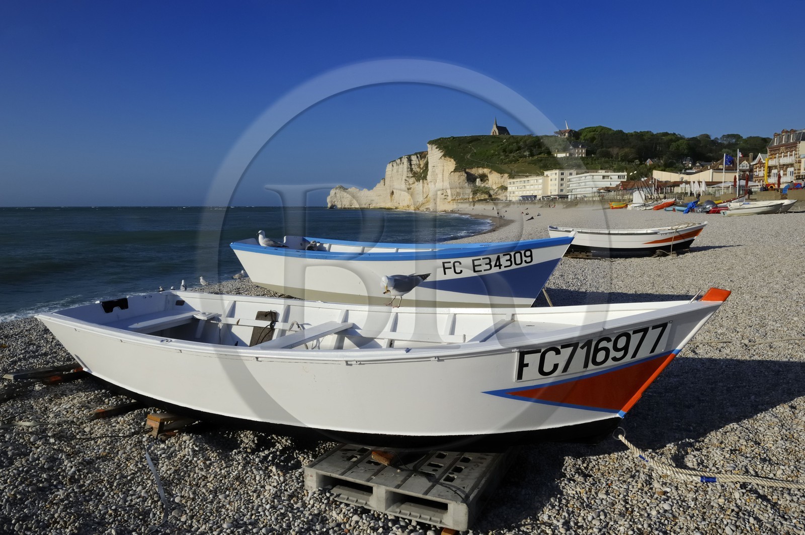 France, Seine-Maritime (76), Pays de Caux, Côte d'Albâtre, Etretat, la falaise d'Amont et l'église Notre-Dame-de-la-Garde depuis la plage de la ville avec les barques de pecheurs