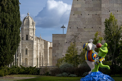 Portugal, Lisbon, Belem, Belem Cultural Centre MAC CCB, The Bathers (1985) by artist Niki de Saint-Phalle and the Jerónimos Monastery (Mosteiro dos Jerónimos), a UNESCO World Heritage Site, in the background