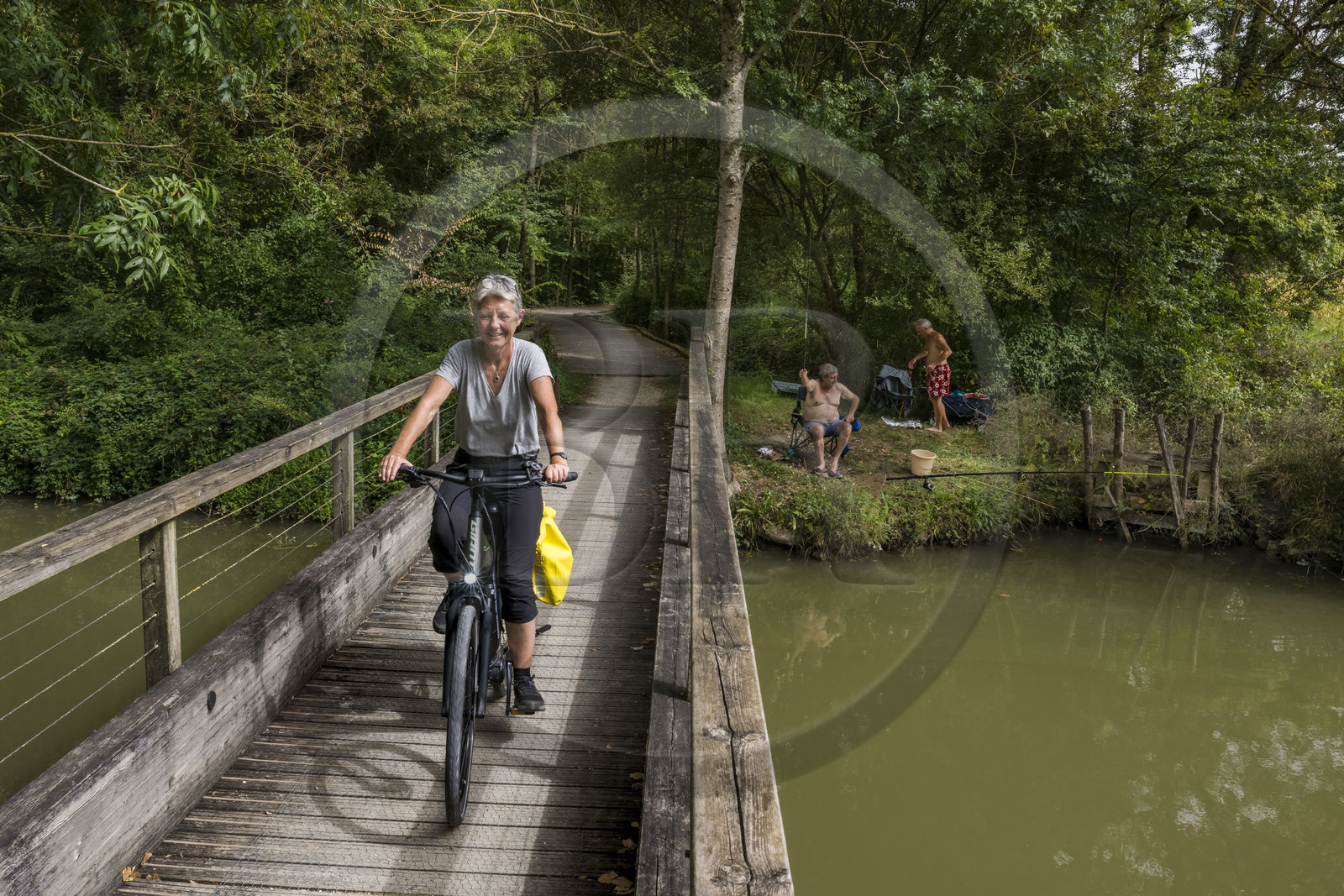 France, Charente Maritime, Saint Agnan, cyclist on the cycle route towards Trizay Abbey, meeting with fishermen along the small canal of Pont-l'Abbé in the Arnoult river valley