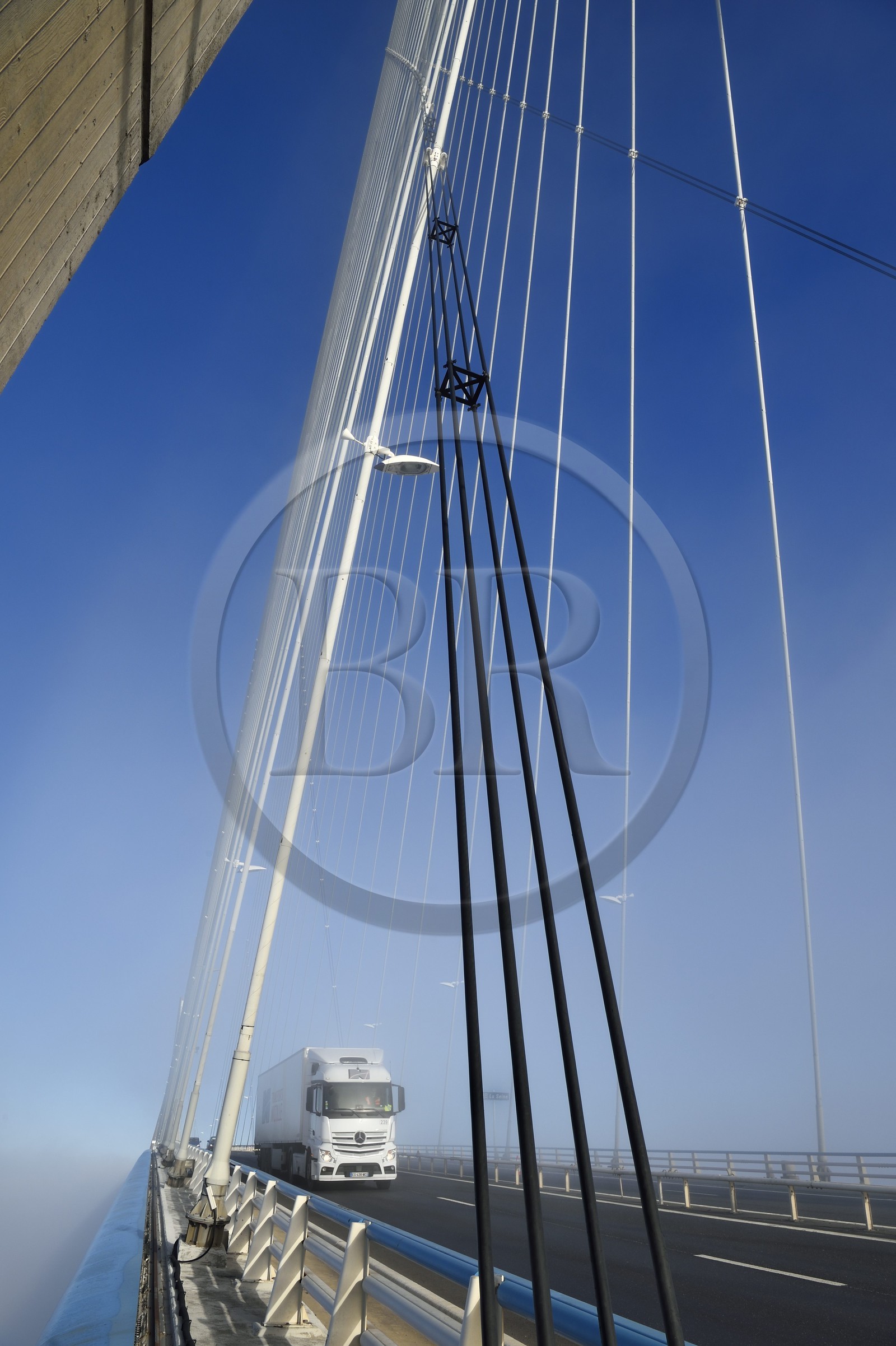 France, entre Calvados (14) et Seine-Maritime (76), le Pont de Normandie enjambe la Seine dans le brouillard