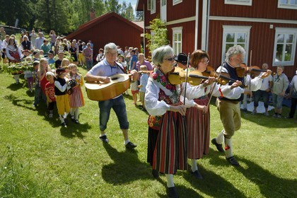 Sweden, Dalarna County, Leksand area, Midsummer celebrations in the tiny hamlet of Sunnanäng, parade of children carrying the maypole before it is erected