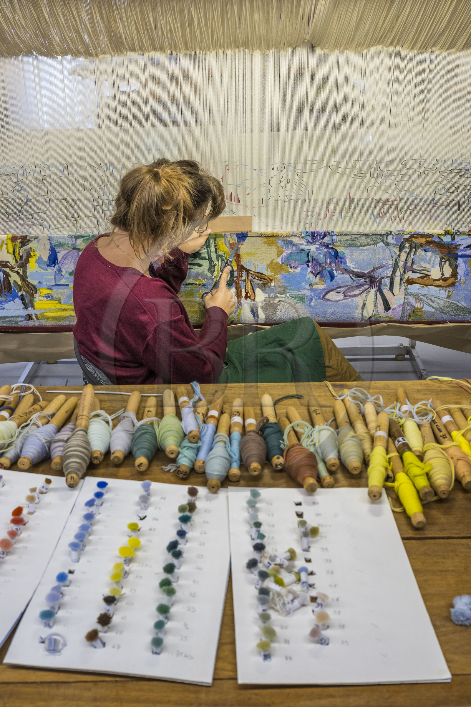 France, Hérault (34), Lodève, Manufacture de la Savonnerie unique annexe de la Manufacture Nationale de tapis de la Savonnerie des Gobelins, réalisation par la licière Kristell Corbinais sur un métier à tisser d'une tapisserie de siège pour banquette L'Iris dans la vallée dessinée par Philippe Borderieux, action de la tonte