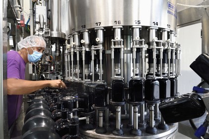 France, Ile de la Reunion, Saint Pierre, domaine de la distillerie Isautier, usine d'embouteillage et d'étiquetage, mise en bouteille de 70cl de rhum arrangé, le conducteur de ligne Khaldu Boualem