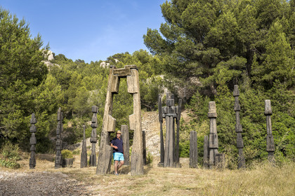 France, Bouches-du-Rhône (13), Marseille, quartier des Goudes, La Friche de l'Escalette dans les ruines d’une ancienne usine de traitement de plomb, le collectionneur et créateur du lieu Eric Touchaleaume devant L'été de la forêt (1964-1966) de l'artiste François Stahly