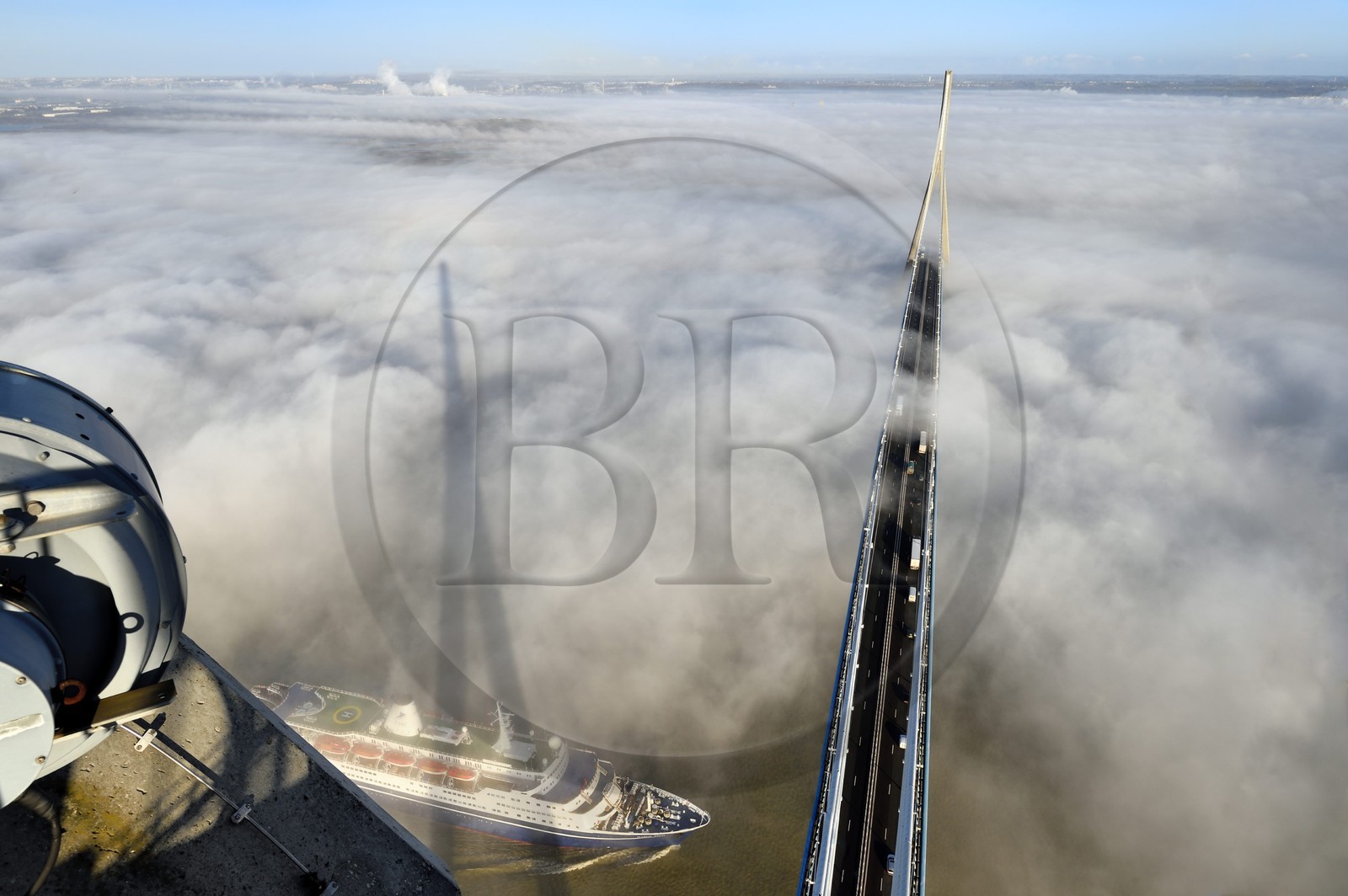 France, entre Calvados (14) et Seine-Maritime (76), bateau de croisière passant sous le Pont de Normandie qui émerge des brumes matinales de l'automne et enjambe la Seine, vue depuis le sommet du pylone sud