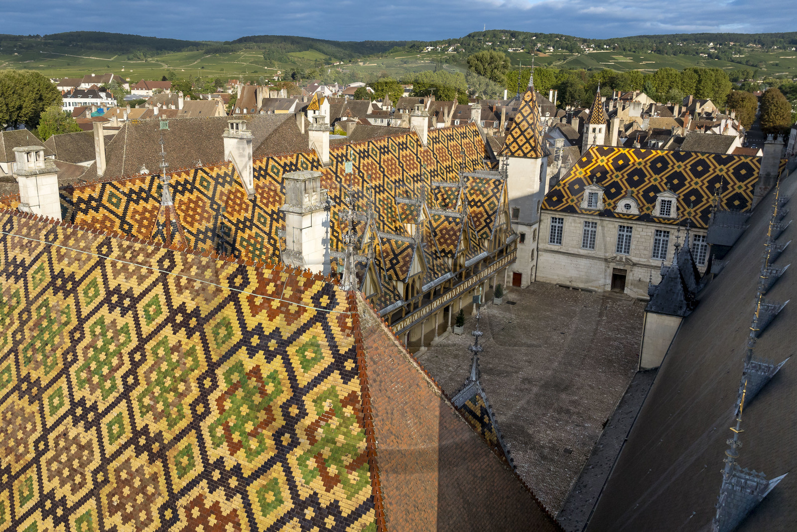 France, Cote d'Or, Beaune, area listed as World Heritage by UNESCO, Hospices de Beaune, Hotel Dieu courtyard of honor, the Côte de Beaune in the background (aerial view)