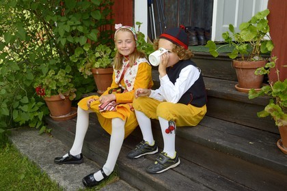 Suède, comté de Dalécarlie, région de Leksand, enfants en costumes traditionnels pour les célébrations du solstice d'été dans le petit hameau de Sunnanäng