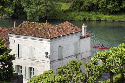 France, Charente-Maritime (17), Saintonge, Taillebourg, maison du village au bord de la Charente vu depuis les terrasses du chateau, kayak de pêche