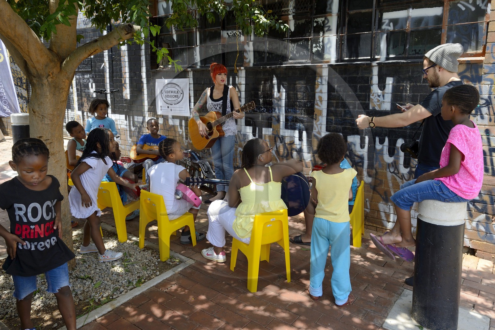 Afrique du Sud, province de Gauteng, Johannesburg, CBD (Central Business District), quartier de Maboneng, Sidewalk Sessions dans Fox street, Kelly Grevler donne des cours de guitare gratuits pour de jeunes enfants dans la rue