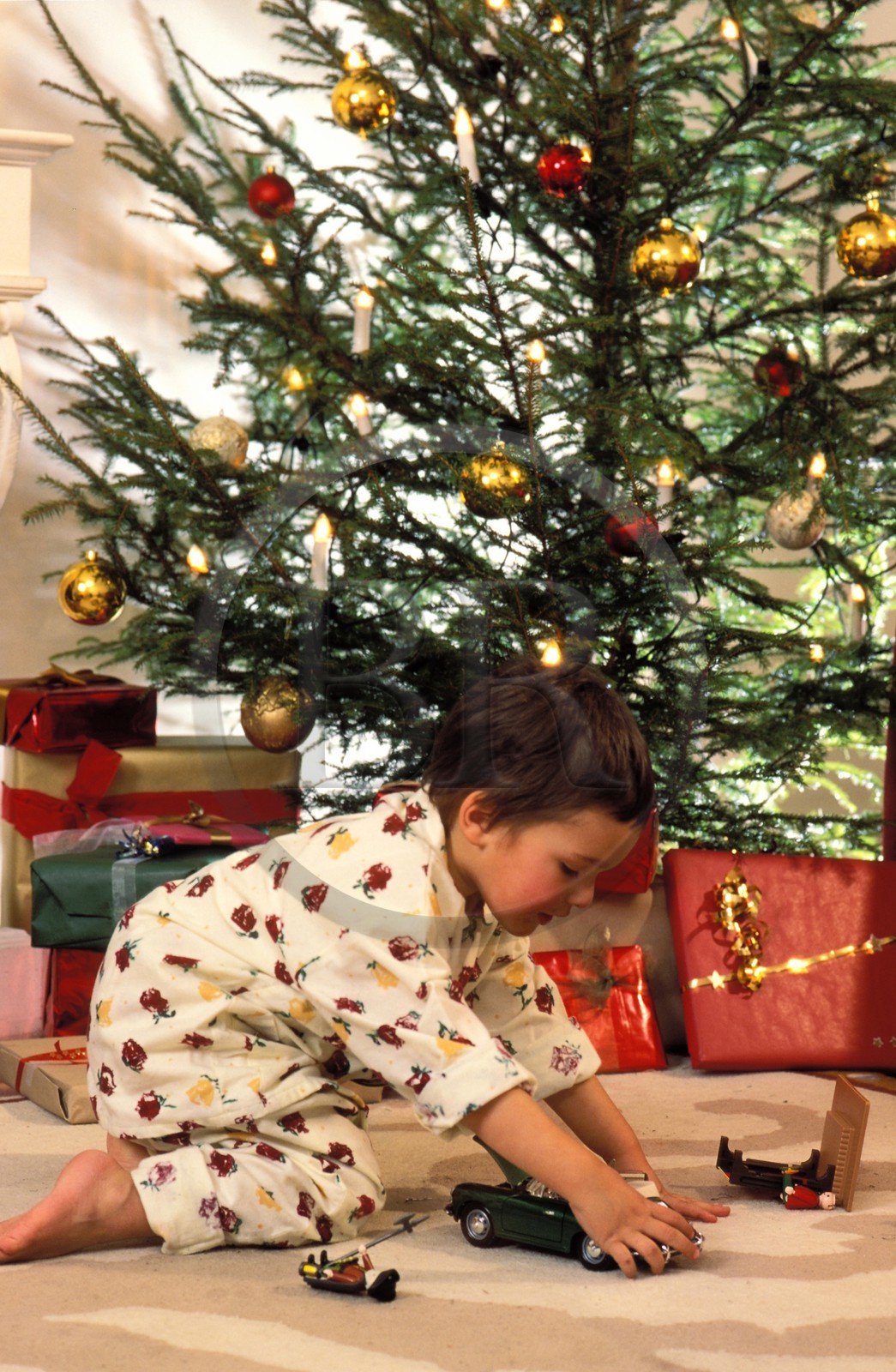 Christmas, little girl with her teddy bear in front of th chrismas tree