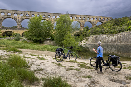 France, Gard (30), le Pont du Gard classé Patrimoine Mondial de l'UNESCO, Grand Site de France, cycliste prenant une pause devant le pont aqueduc romain qui enjambe le Gardon