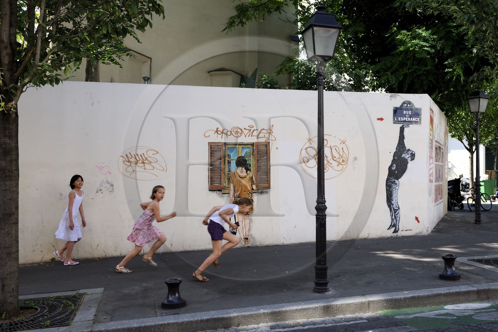 France, Paris (75), quartier de la Butte-aux-Cailles, enfants courant rue de l'Espérance sous un graffity de Lézards