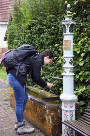 France, Bas-Rhin (67), Parc naturel régional des Vosges du Nord, Niedersteinbach, randonneuse buvant à une des nombreuses fontaines du village