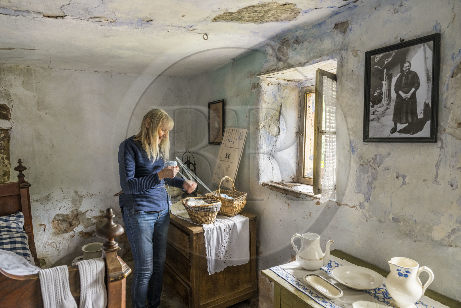 France, Bas Rhin, Parc regional des Vosges du nord (Northern Vosges Regional Natural Park), Eschbourg, Maisons des Rochers (Rocks houses) of Graufthal, semi-troglodytic houses of the 18th century and inhabited until 1958, the former village teacher Annette Oster demonstrates how to use an affiquet to knit