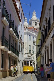 Portugal, Lisbon, Alfama district, tram (electricos) along Rua das Escolas Gerais with the tower of Sao Vicente de Fora church