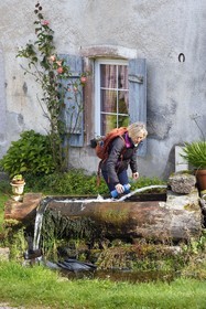 France, Vosges, Le Valtin, village in the upper valley of the Meurthe, hiker filling her water bottle at the fountain