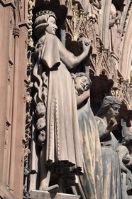 France, Bas-Rhin (67), Strasbourg, vieille ville classée au Patrimoine Mondial de l'UNESCO, la cathédrale Notre-Dame, la facade occidentale, portail latéral sud (fin du XIIIème siècle), Vierges folles séduites par le Tentateur, élégant jeune homme habillé à la mode du temps, qui présente la pomme avec assurance mais masque mal son dos envahi de batraciens et serpents