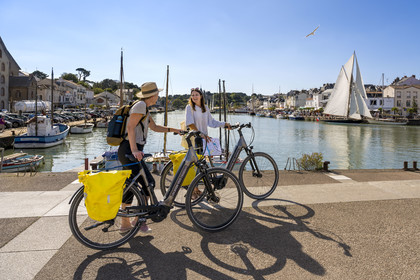 France, Loire-Atlantique (44), Pornic, cyclistes en vélo électrique visitant le port, le voilier Pen Duick sous voile en arrière plan