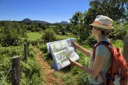 France, Puy-de-Dôme (63), Le Bouchet, Parc naturel régional des Volcans d'Auvergne, randonneuse sur le sentier des puys de Jumes et de la Coquille, en arrière plan le volcan le Puy Chopine à gauche et le Puy de Dome à droite