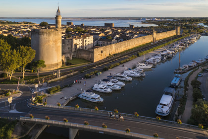 France, Gard (30), Aigues-Mortes, la ville médiévale entourée par ses remparts, la Tour de Constance et le port du canal du Rhône à Sète au premier plan, les marais salants (Salins du Midi) en arrière plan (vue aérienne)