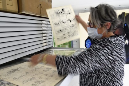 France, Charente (16), Angoulême, Cité internationale de la bande dessinée et de l’image (CIBDI), dans les réserves du musée de la BD, Caroline Janvier faisant des recherches sur les collections, ici un encrage original de Tintin au Tibet par Hergé