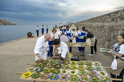 France, Bouches-du-Rhône (13), Marseille, Zone Euroméditerranée, grand port maritime de Marseille (GPMM), la digue du large, convives attablés à une grand table de banquet dressée par le chef Emmanuel Perrodin dans le cadre des Diners Insolites, derniers préparatifs au plats