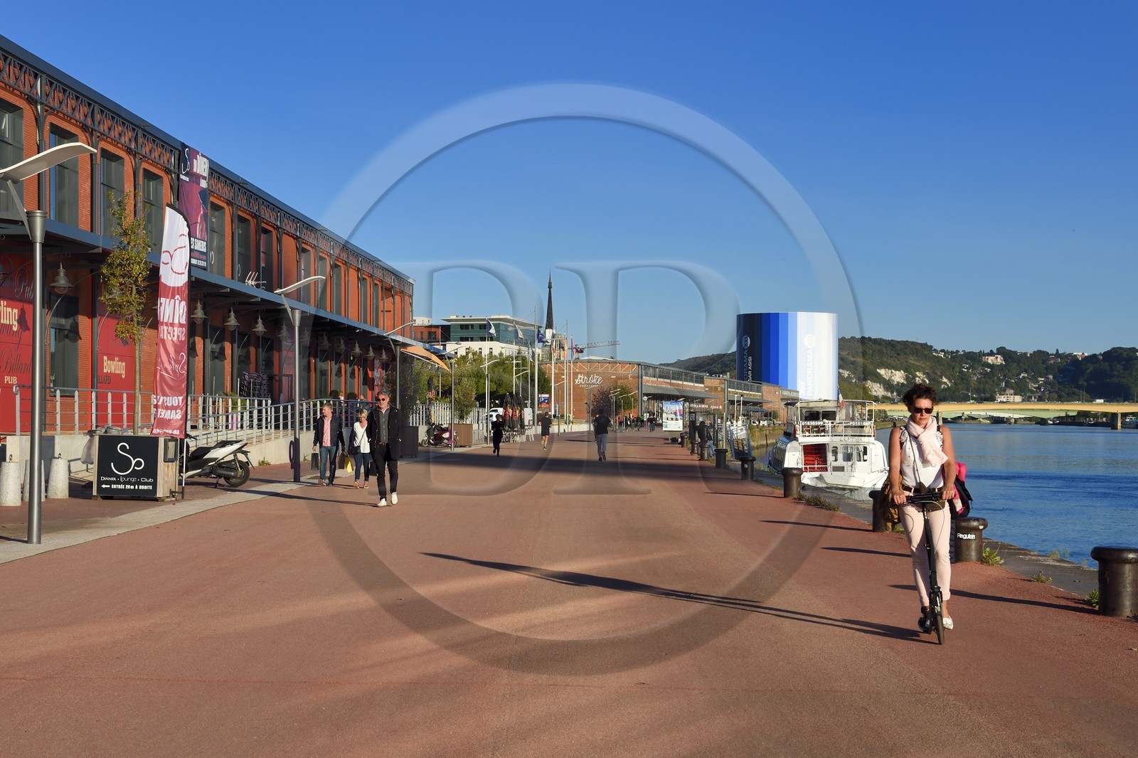 France, Seine Maritime, Rouen, woman on a push scooter and the Panorama XXL on the right bank of the Seine in the background