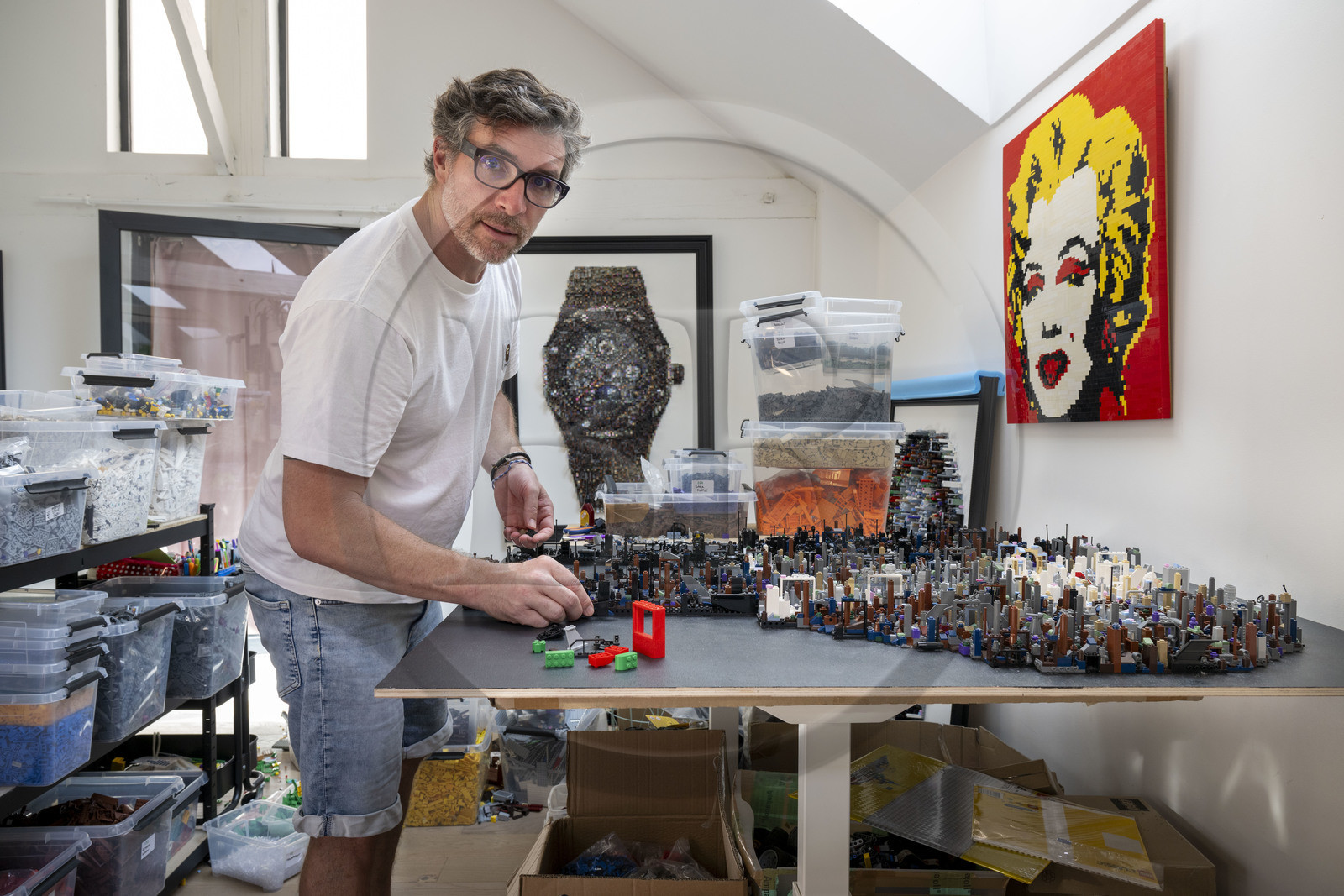 France, Côte-d'Or (21), Dijon, l'artiste Aymeric Gillet alias M'Brick dans son atelier rempli de caisses de Légo multicolores utilisés pour créer des tableaux géants pixellisés inspirés par la pop culture