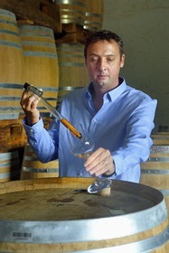 France, Reunion island (French overseas department), Saint Pierre, estate of the Isautier distillery, aging of old rums in the cellars between 6 and 14 months in new barrels then several years afterwards by batch in red barrels, Cyril Isautier director of the rums and punches branch of the Isautier group takes a sample with a pipette for tasting