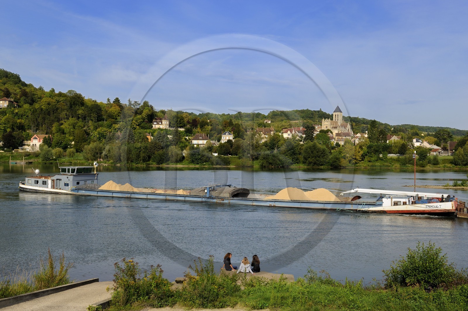 France, Val-d'Oise, a barge on the Seine river in front of Vetheuil and its Notre Dame church painted by Claude Monet