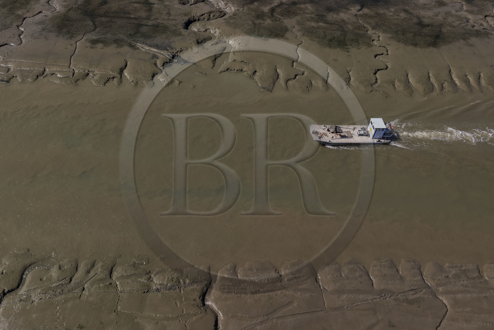 France, Charente-Maritime (17), Ile d'Oléron, le Chateau-d'Oléron, bateau ostréicole dans le chenal de sortie du port à marée basse (vue aérienne)