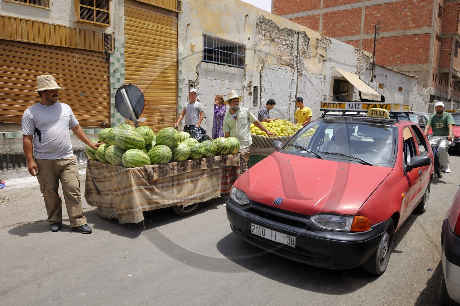 Maroc, région de l'Oriental, Oujda, vendeurs de pastèques et petit taxi