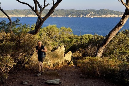 France, Var (83), Iles d'Hyères, parc national de Port Cros, Ile de Port-Cros, randonneuse sur un sentier cotier et l'Ile de Bagaud qui est une réserve intégrale en arrière plan