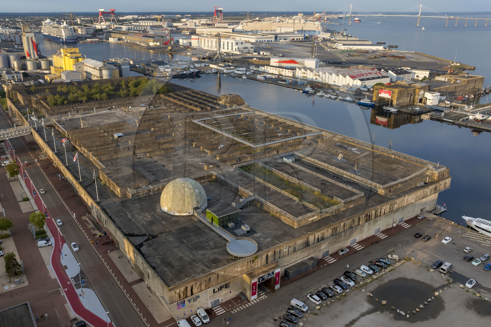 France, Loire-Atlantique (44), Saint-Nazaire, les anciennes bases sous-marines allemandes construites lors de la dernière guerre mondiale bordent le bassin à flot du port de Saint-Nazaire, en arrière plan à gauche le bassin de Penhoët et à droite le pont de Saint-Nazaire (vue aérienne)