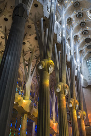 Espagne, Catalogne, Barcelone, quartier de l'Eixample, basilique de la Sagrada Familia de l'architecte du modernisme catalan Antoni Gaudi classée Patrimoine Mondial de l'UNESCO, au dessus du noeud, les colonnes du vaisseau central (nef) se subdivisent en branches tel un arbre, éclairées par les projections chaudes des vitraux du coté de la facade de la Passion