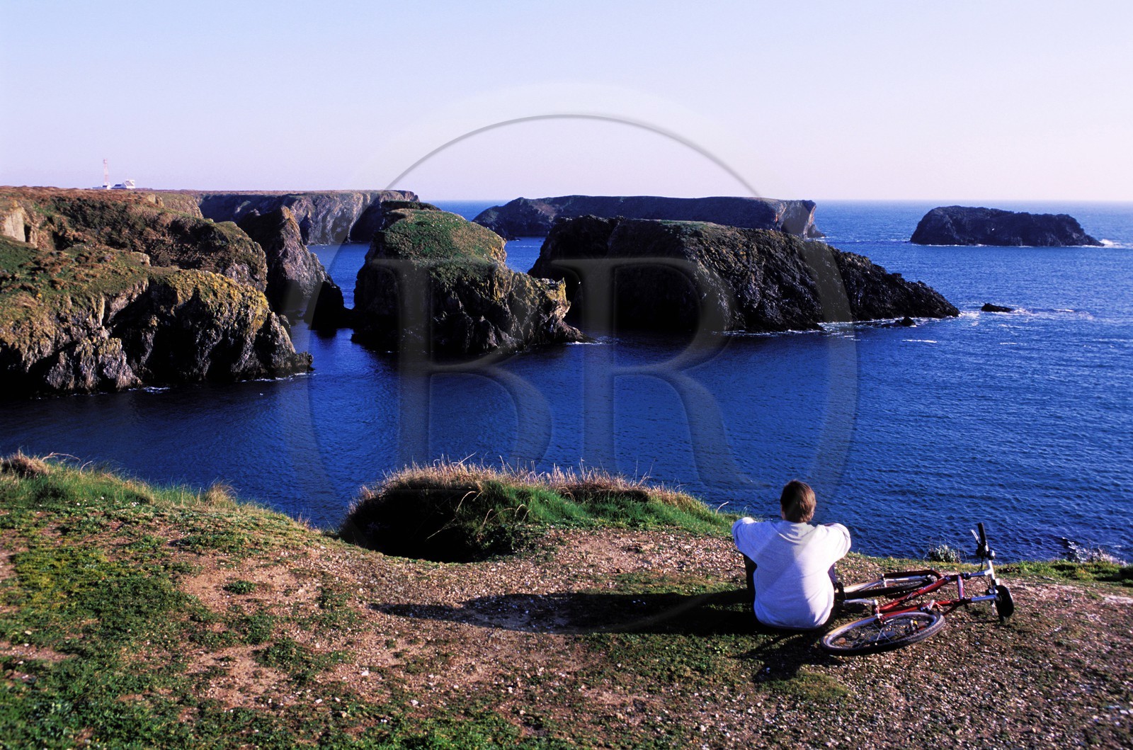 France, Morbihan, Belle Ile island, a cyclist admiring the rocky chaos of Port Goulphar