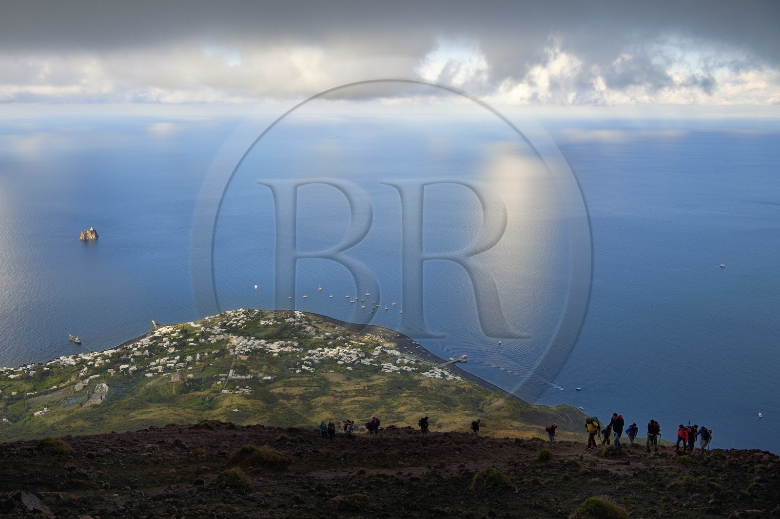 Italie, Sicile, iles Eoliennes, classées Patrimoine Mondial de l'UNESCO, ile de Stromboli, randonneurs dans l'ascension du volcan, le village de Stromboli et l'ilot de Strombolicchio en arrière plan