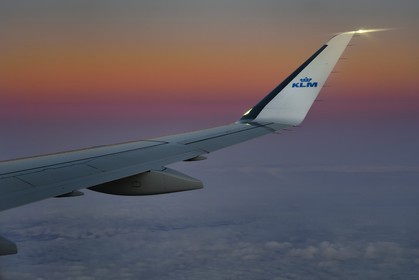 Norvège, aile d'un avion KLM en vol au dessus des nuages au coucher de soleil