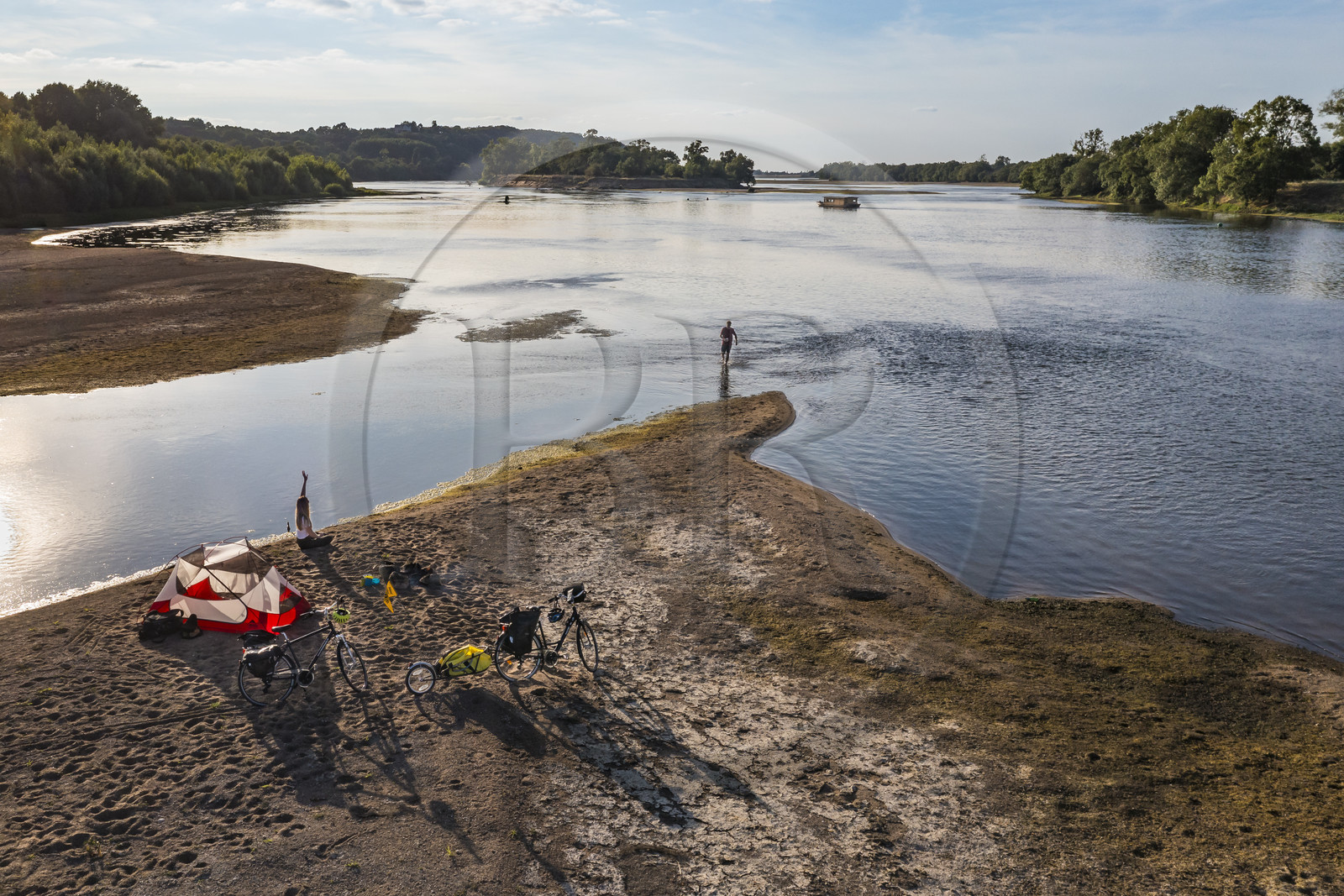 France, Maine-et-Loire (49), vallée de la Loire classée au Patrimoine Mondial par l'UNESCO, randonnée à bicyclette le long des berges de la Loire, campement pour la nuit sur un des bancs de sable formant des îles sur la Loire, une gabarre (bateau traditionnel à fond plat) en arrière plan (vue aérienne)